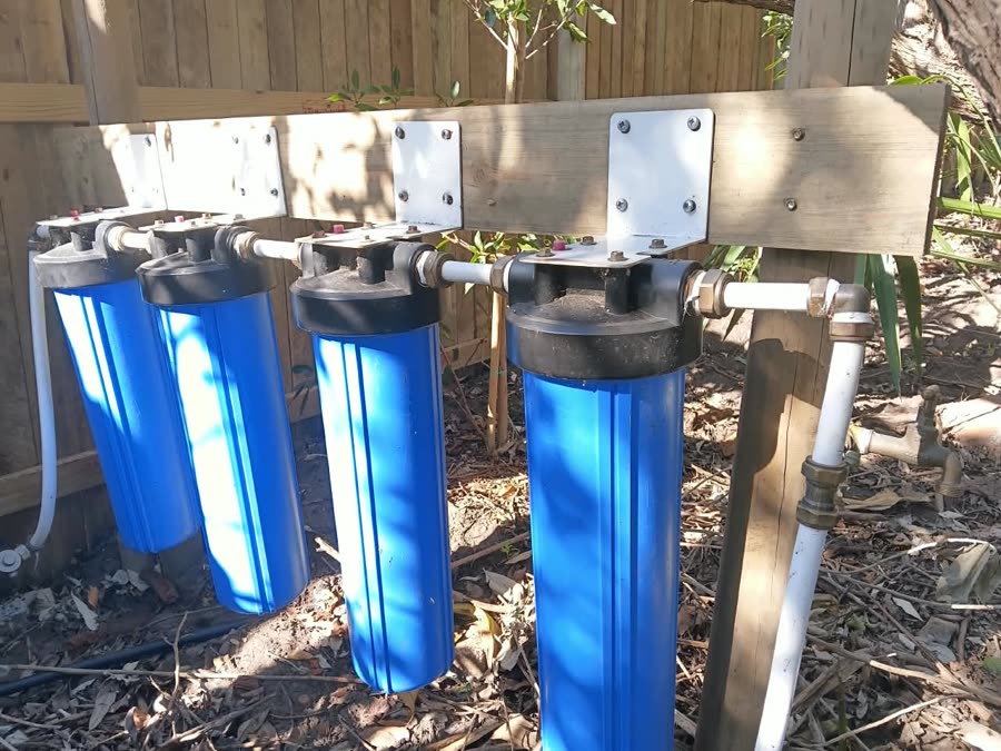 Four-stage water filter bank mounted on a timber frame outdoors