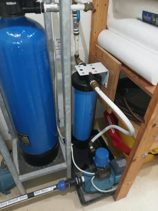 Indoor rainwater installation with storage tank, filter housing and pump